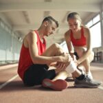 woman helping sportsman with injury during cardio training